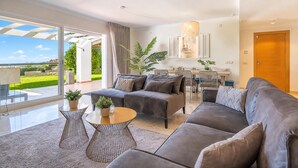Una sala de estar moderna con sofá, mesa de centro y plantas en macetas.