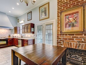 Una cocina con armarios de madera, una mesa de comedor y una chimenea de ladrillo.