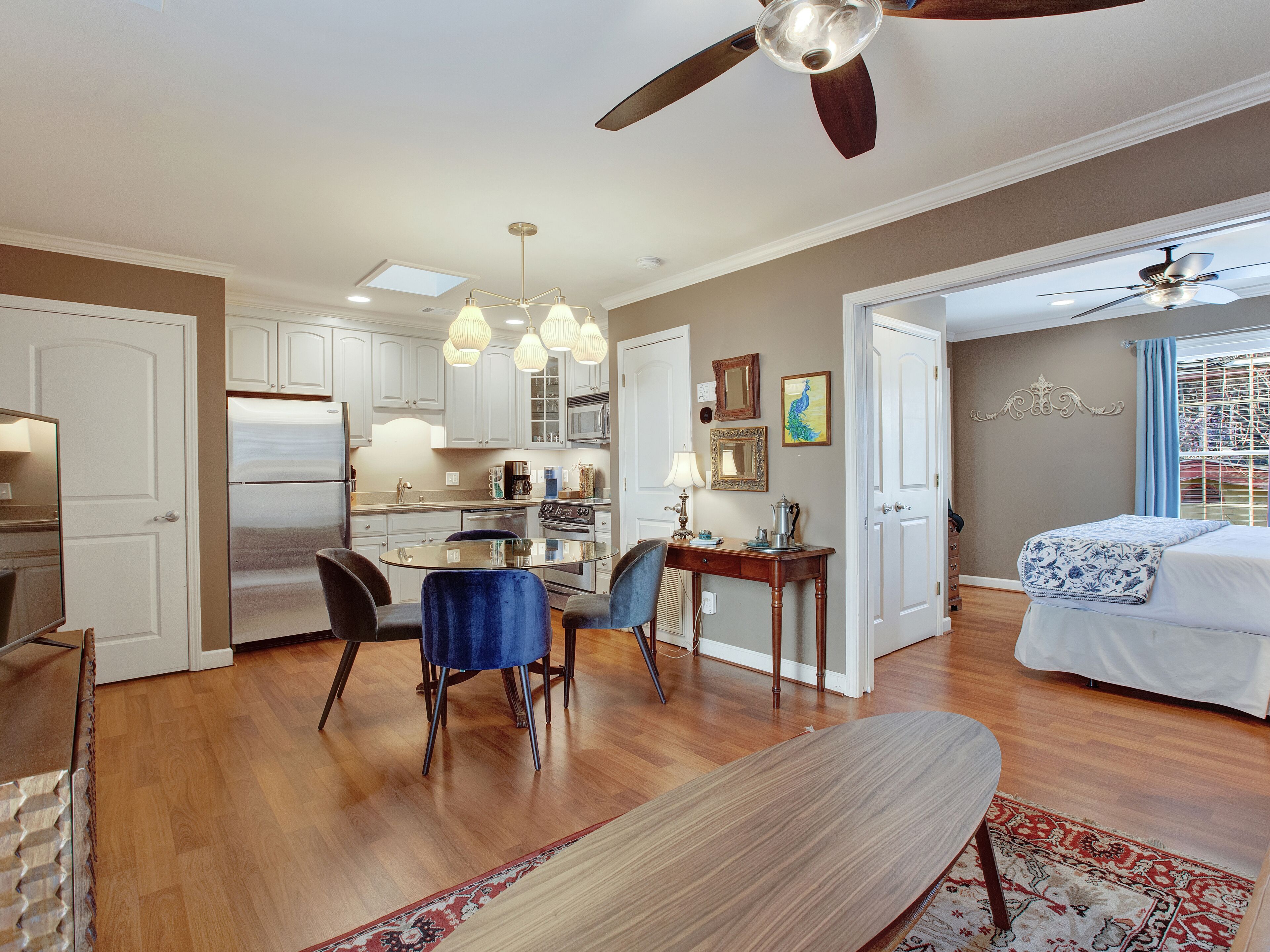 Uma cozinha espaçosa com eletrodomésticos modernos, uma sala de jantar com mesa de vidro e um quarto com uma janela grande.