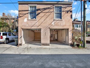 Two-story building with a garage entrance and symmetrical facade.