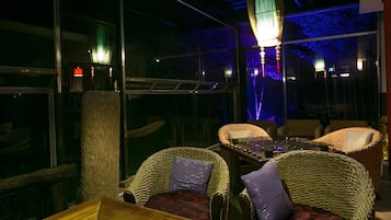 A dimly lit interior with wicker furniture and a table.