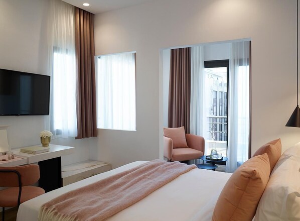 A hotel room with a bed, a desk with a chair, a television, and a view of the city through large windows. - The Marblous Athens (Athens)