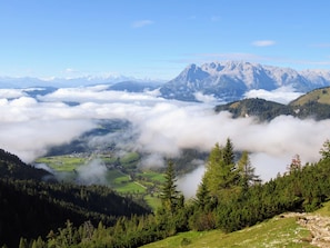 A mountainous landscape with a valley, forested areas, and a town below. - Luxury penthouse with idyllic mountain views (Werfenweng)