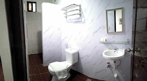 A bathroom with a toilet, a sink, and a mirror. - Lolas Lodge (Boracay Island)