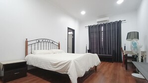 A bedroom with a bed, bedside table, and a desk with a chair. - OYO 90203 Emma Sukma Homestay (Kuching)