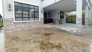 A modern building with a large window, stone accents, and a covered outdoor area. - OYO 90203 Emma Sukma Homestay (Kuching)