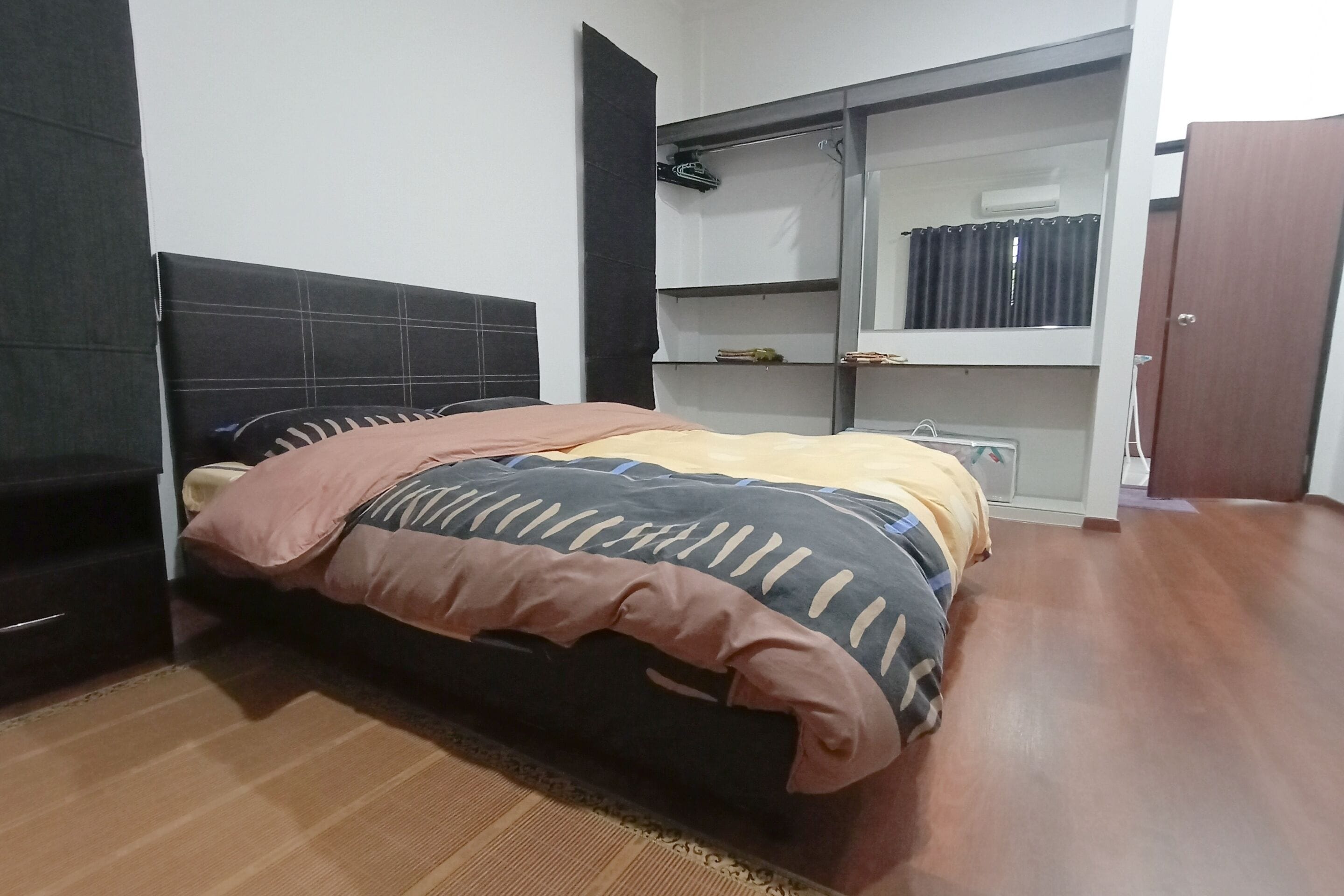 Een slaapkamer met een bed, een kledingkast en een spiegel.