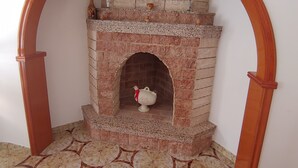 Una chimenea con repisa de ladrillo y una figura decorativa de pájaro en el hogar.