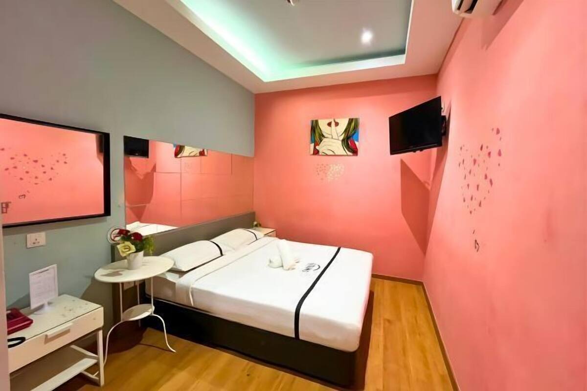 Une chambre à coucher moderne avec un lit, une table de chevet et des œuvres d’art accrochées aux murs.