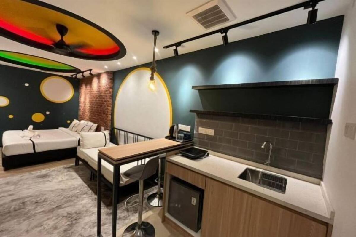 Une pièce compacte comprenant un coin cuisine, un lit, une petite table à manger et un canapé.