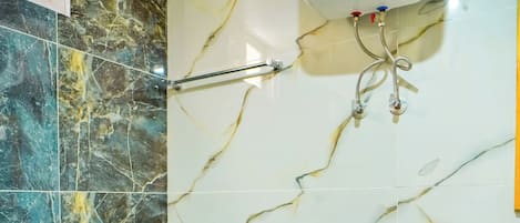 Casa de banho com sanita, esquentador e um cesto de lixo.