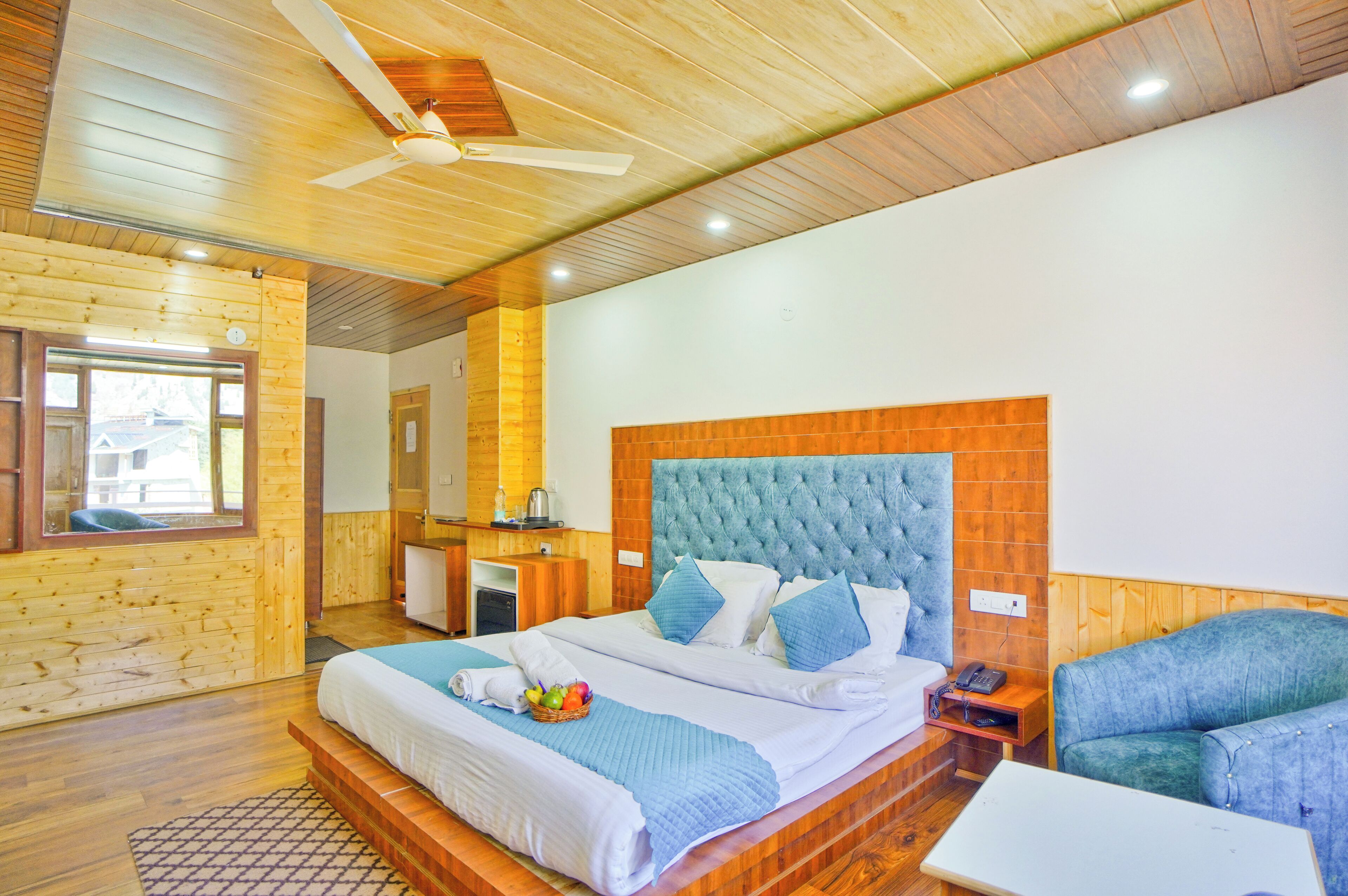 A wooden-paneled room with a bed, a desk, and a chair.