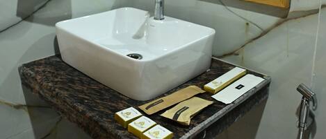 A bathroom with a marble sink, a wooden-framed mirror, and a towel hanging on a ring.