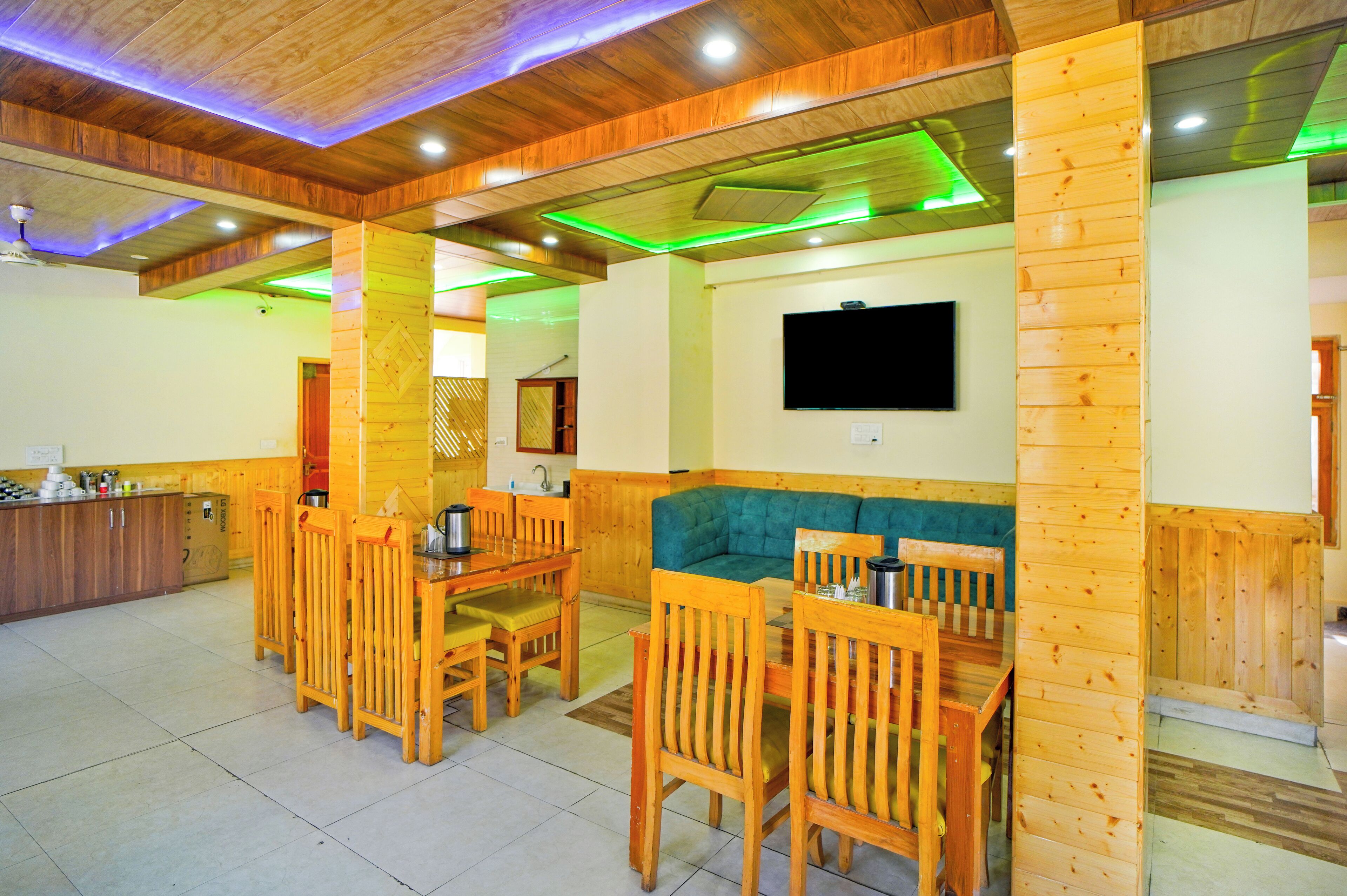 A wooden interior with a dining area, a bar, and a seating area with a TV.