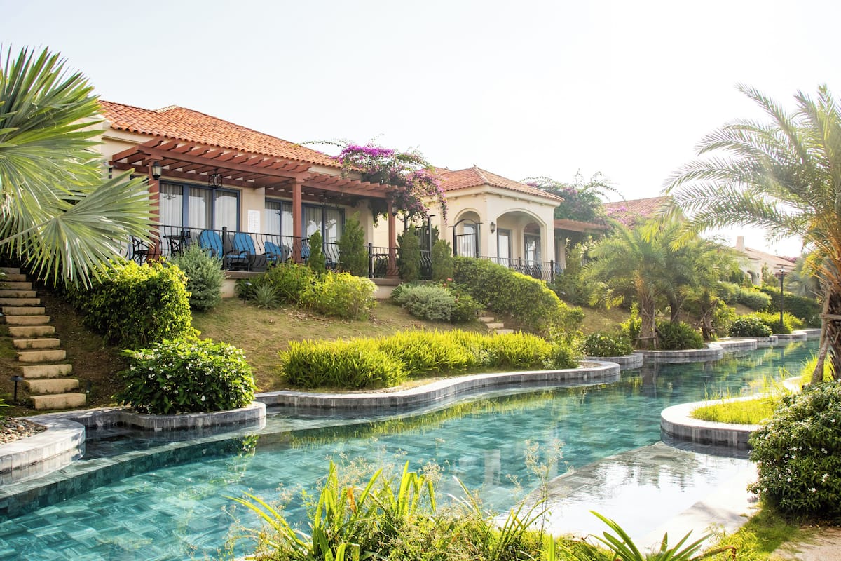 A pool area with a house in the background.