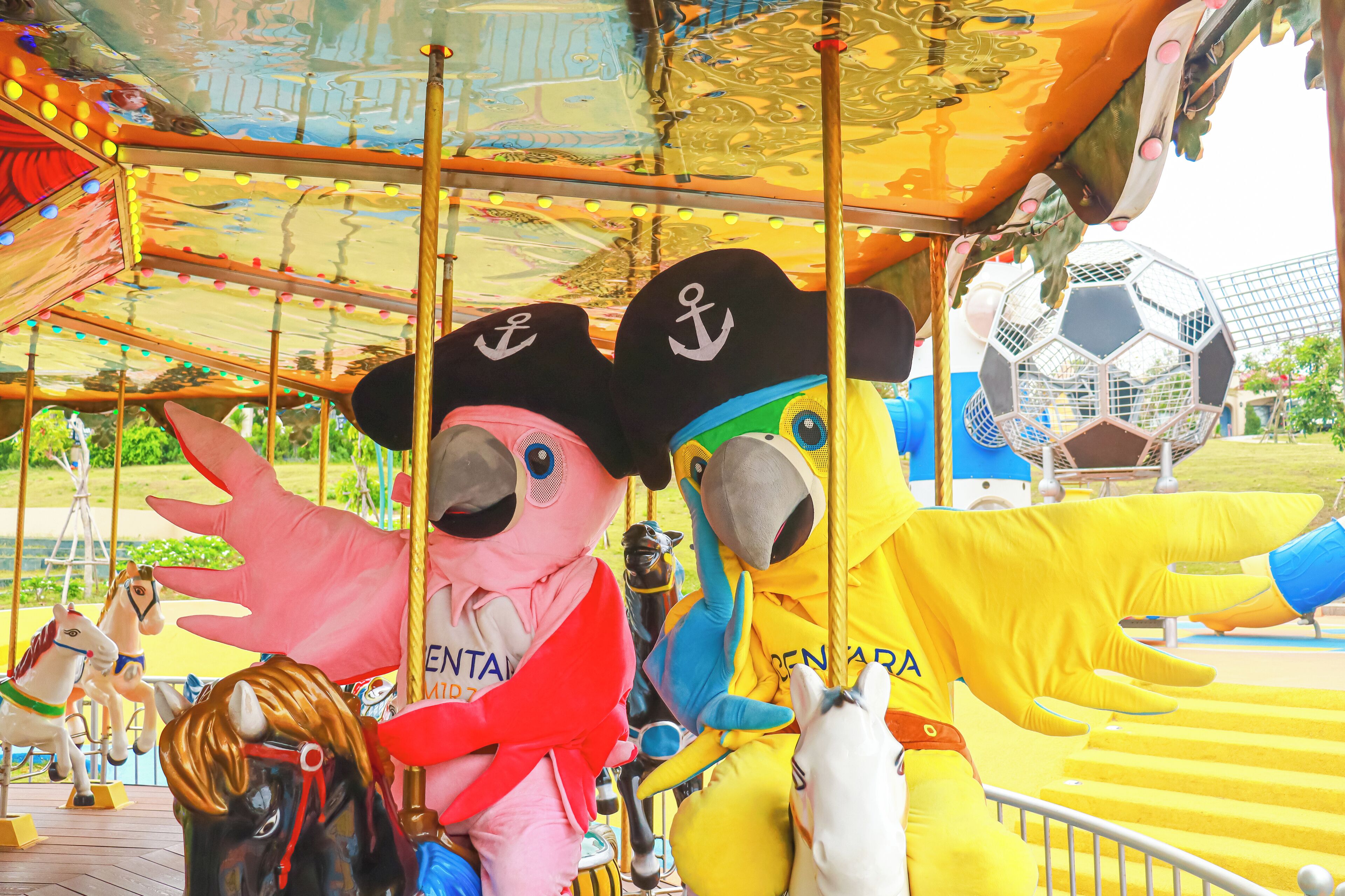 Un carrusel con diversas figuras de animales y personajes, incluyendo un oso y un caballo, además de un balón de fútbol.