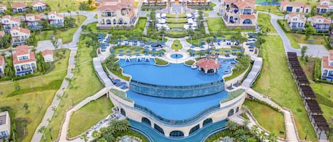 A resort with a central pool, multiple guest villas, and a landscaped garden.