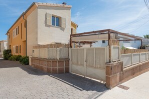 Een tweelaags huis met een balkon en een overdekt terras.
