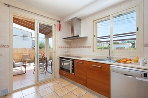 Een moderne keuken met een vaatwasser, oven en een raam met uitzicht op de achtertuin.