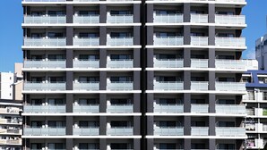 Un edificio moderno a più piani con balconi, situato in prossimità di un corso d'acqua.