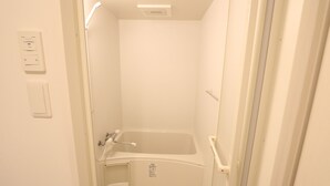 Un bagno piccolo e bianco con vasca, water e doccia.