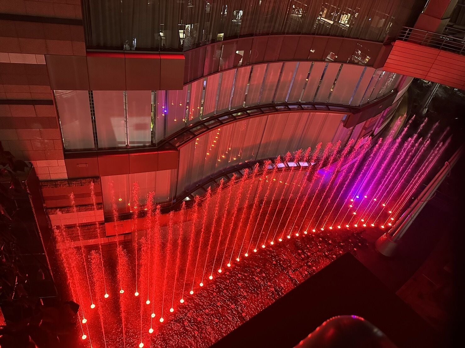 A multi-level atrium with a water feature and lighting.