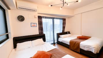 A hotel room with two beds, a ceiling light fixture, an air conditioning unit, a clock, and a window with curtains.