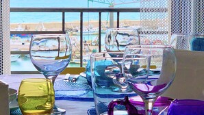 A table with multiple glasses and a view of the sea through a window. - The fisherman's house (Sciacca)