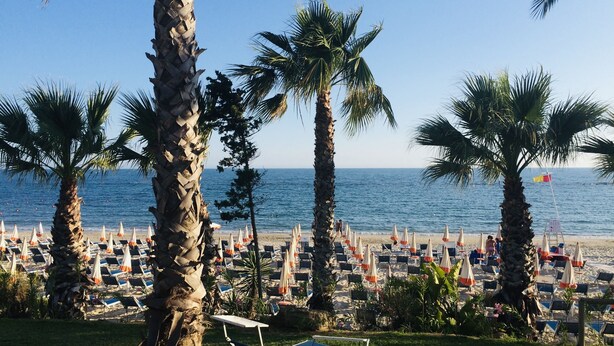 A beach with rows of sun loungers and palm trees. - The fisherman's house (Sciacca)