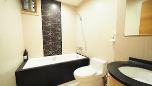 A bathroom with a bathtub, toilet, and sink.