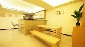 A modern kitchen with a microwave, a wooden bench, and a dining table.