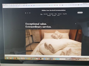 Une page web présentant des hébergements de qualité, mettant en particulier l’accent sur une chambre où le lit est parfaitement fait et où des serviettes sont soigneusement pliées.