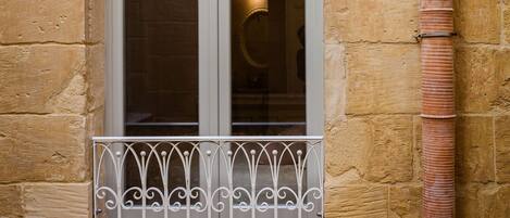A window with a metal railing and a light fixture above it.
