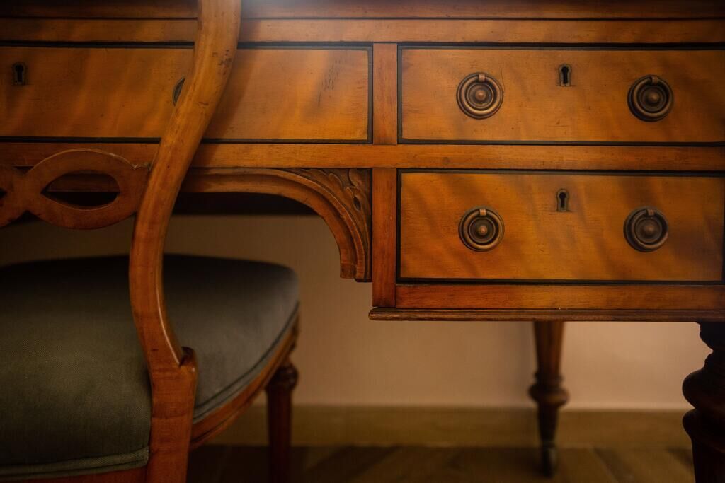 A wooden dresser with multiple drawers and a curved design on the left side.