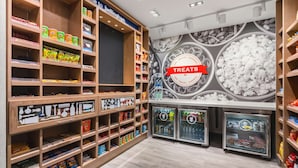A well-organized snack and treat section with shelves stocked with various products, a 'Treats' sign, and refrigerated display cases.