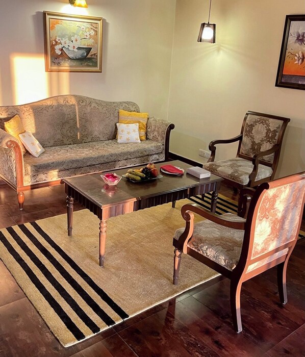 A living room with a sofa, a coffee table, and two chairs.