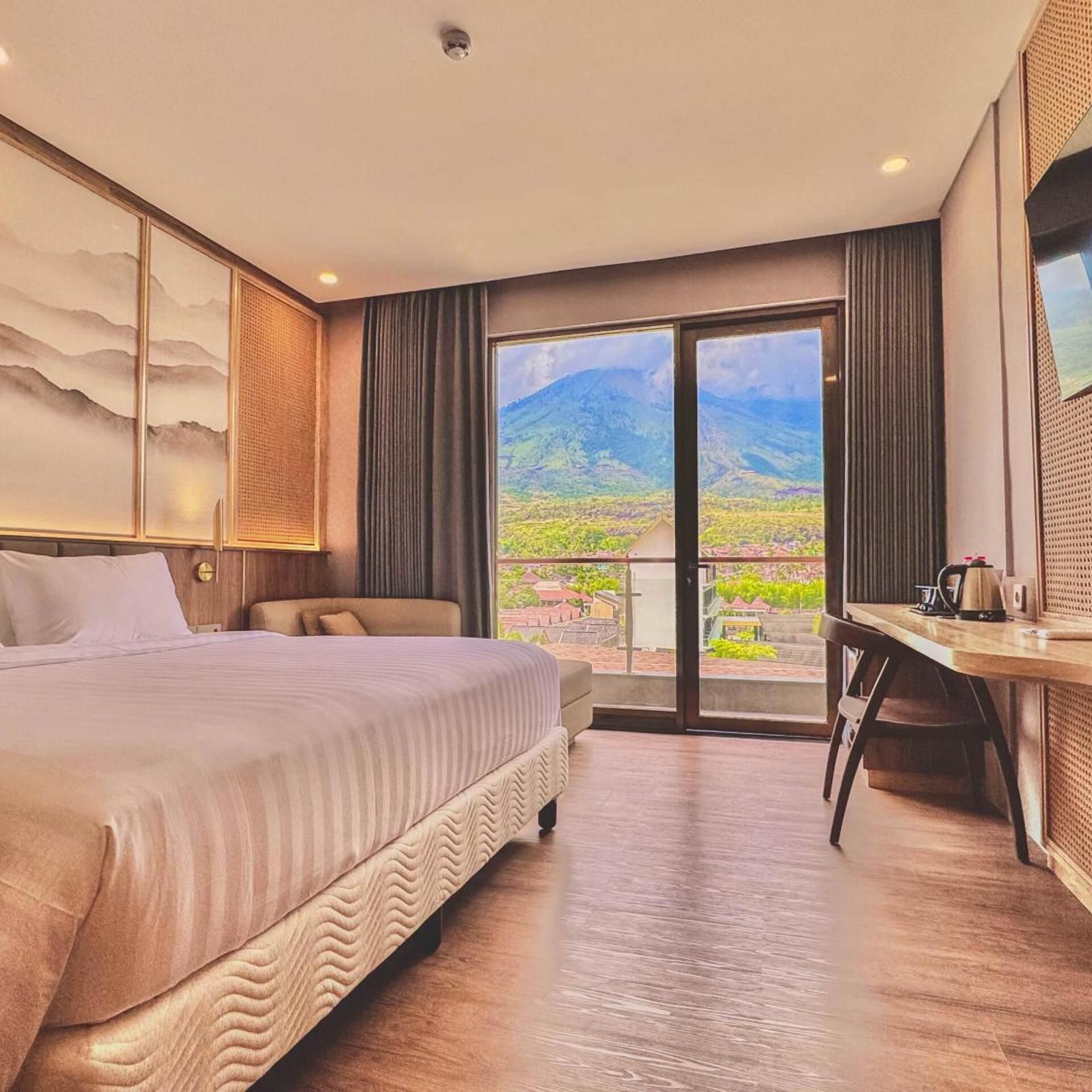 Une chambre d’hôtel avec un lit, un bureau et une vue sur les montagnes.