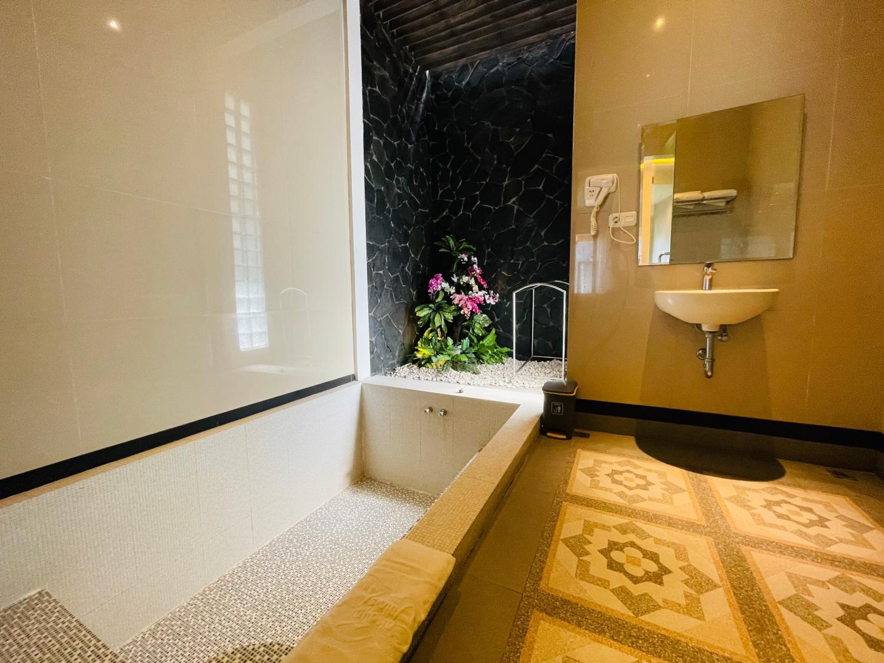 Une salle de bain moderne avec une baignoire, un lavabo et un miroir.