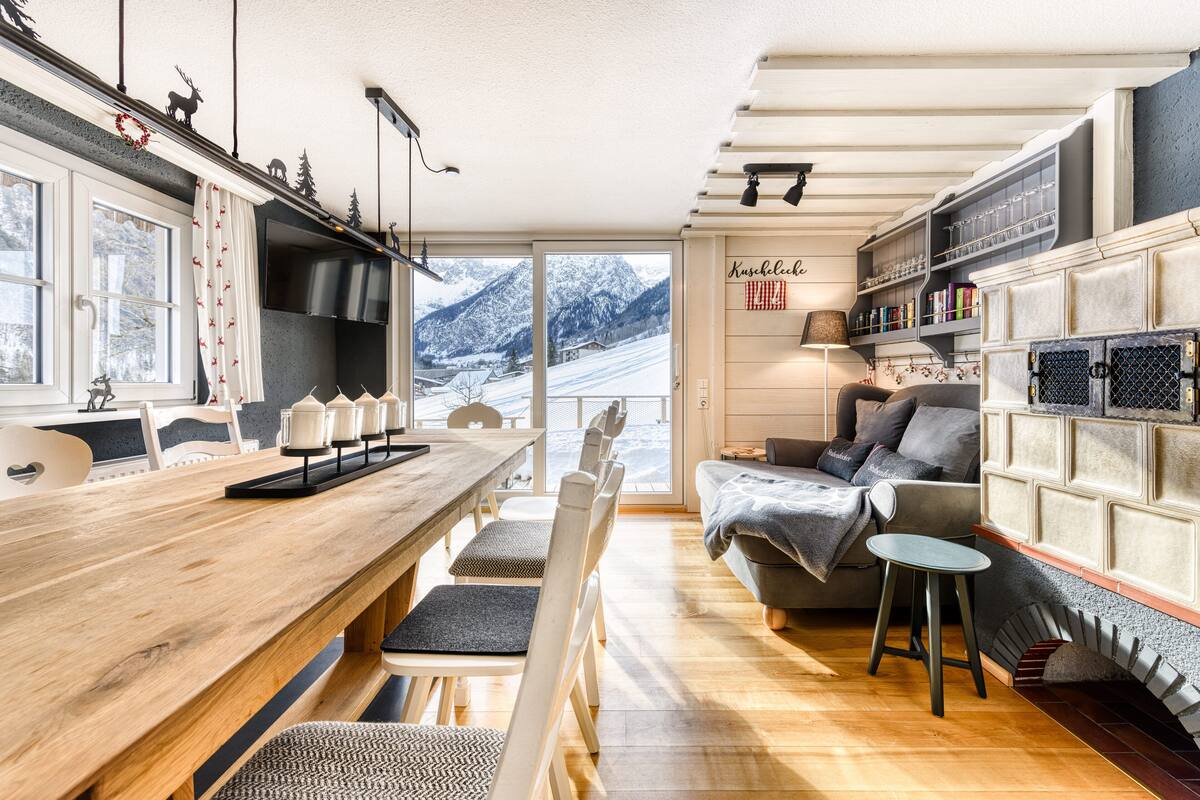 A cozy living area with a wooden dining table, a sofa, and a fireplace.