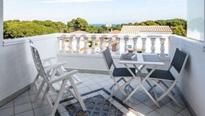 A balcony with white railings, two chairs, a small table, and a view of the sea and greenery. - Superb summer house with swimming pool, parking, wifi and air conditioning  (L'Escala)