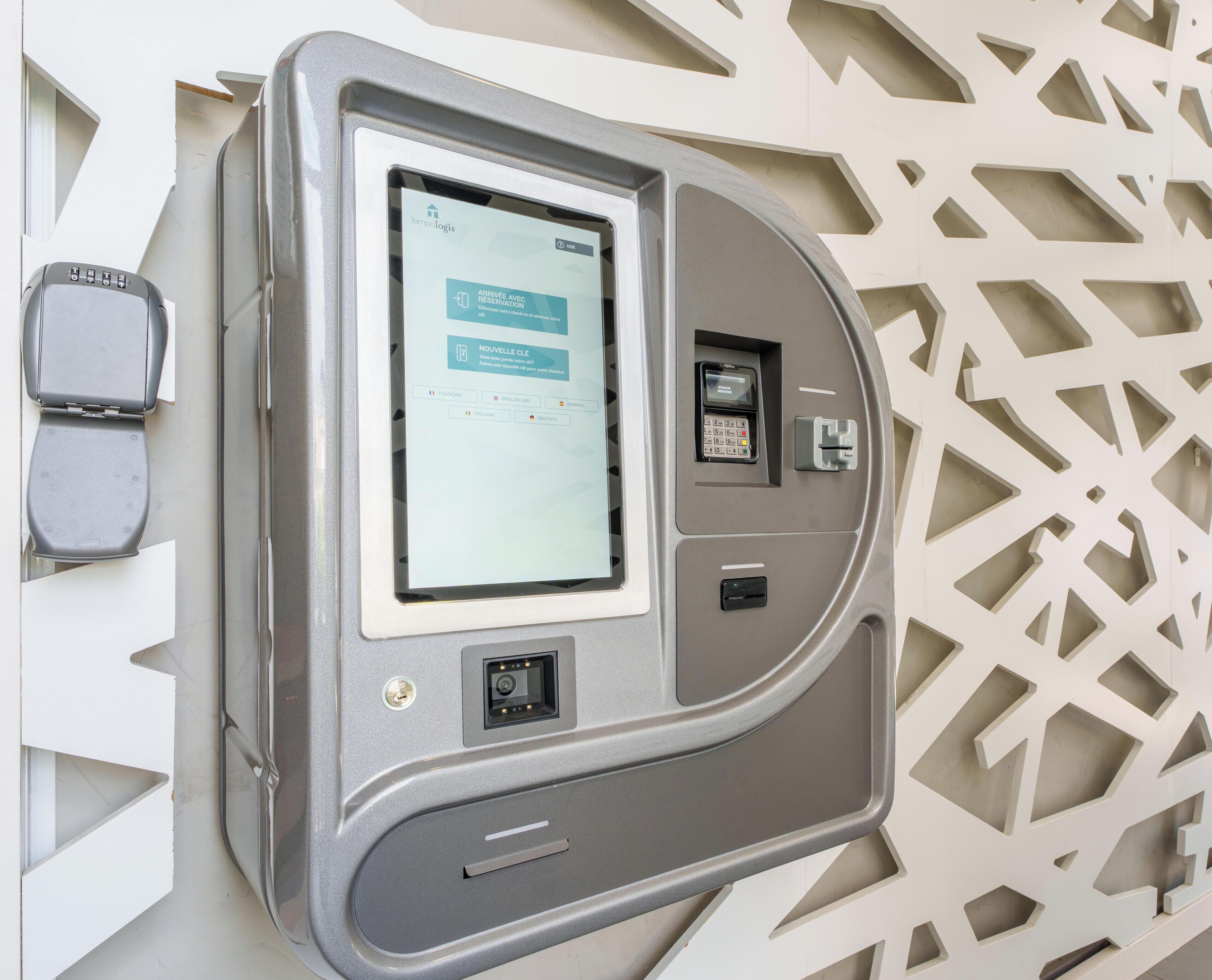 A self-service kiosk with a screen, card reader, and keypad, likely for hotel check-in or payment.
