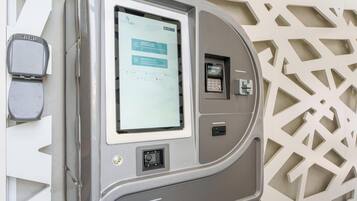 A self-service kiosk with a screen, card reader, and keypad, likely for hotel check-in or payment.