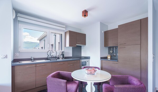 Una cocina moderna con armarios de madera, horno empotrado y ventana con vistas panorámicas.