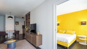 A modern hotel room with a bed, a desk, and a seating area. - Tempologis Le Saint Germain Grenoble (Grenoble)