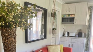 A living room with a red sofa, a decorative plant, and a patterned rug. - Highlands Escape  Moss Vale (Moss Vale)