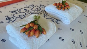 A neatly made bed with two towels, each adorned with a bouquet of tulips. - Highlands Escape  Moss Vale (Moss Vale)