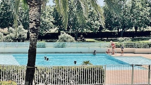 Una piscina rodeada de exuberante vegetación y palmeras.