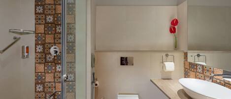 A bathroom with a shower, toilet, and sink.