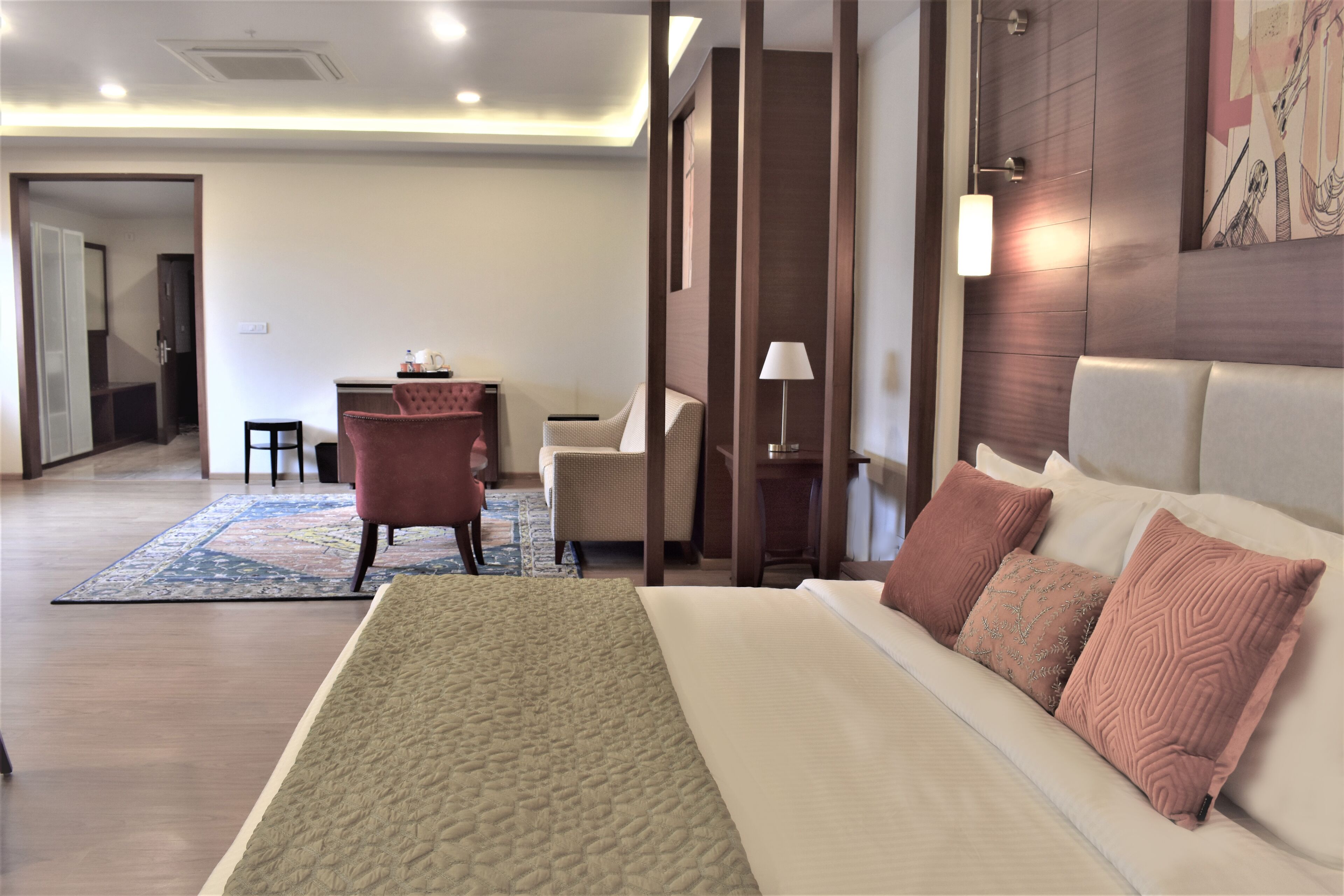 A hotel room with a large bed, a desk, and a chair.