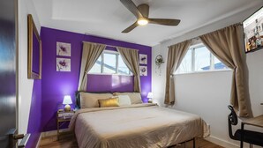 A bedroom with a bed, a desk, a chair, a ceiling fan, and a window with curtains. - HotTub PS5 GameRoom Theater PoolTable 420 (Denver)